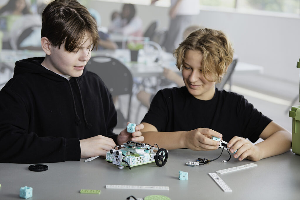 Two male students building the micro:bit Electric Vehicles project from the Climate Action Kit
