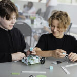 Two male students building the micro:bit Electric Vehicles project from the Climate Action Kit