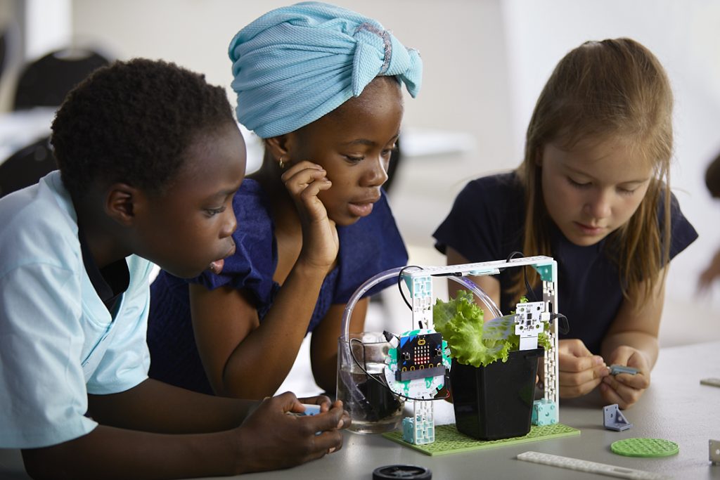 Elementary students using Microsoft MakeCode's block programming software to build and test a hydroponics kit for learning computer science with the BBC micro:bit