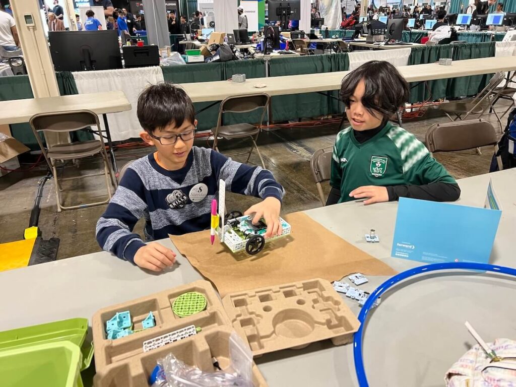 Two students building the micro:bit Tree Seeder from the Climate Action Kit