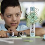Male student looking at the Wind Turbine Climate Action Kit project on the desk