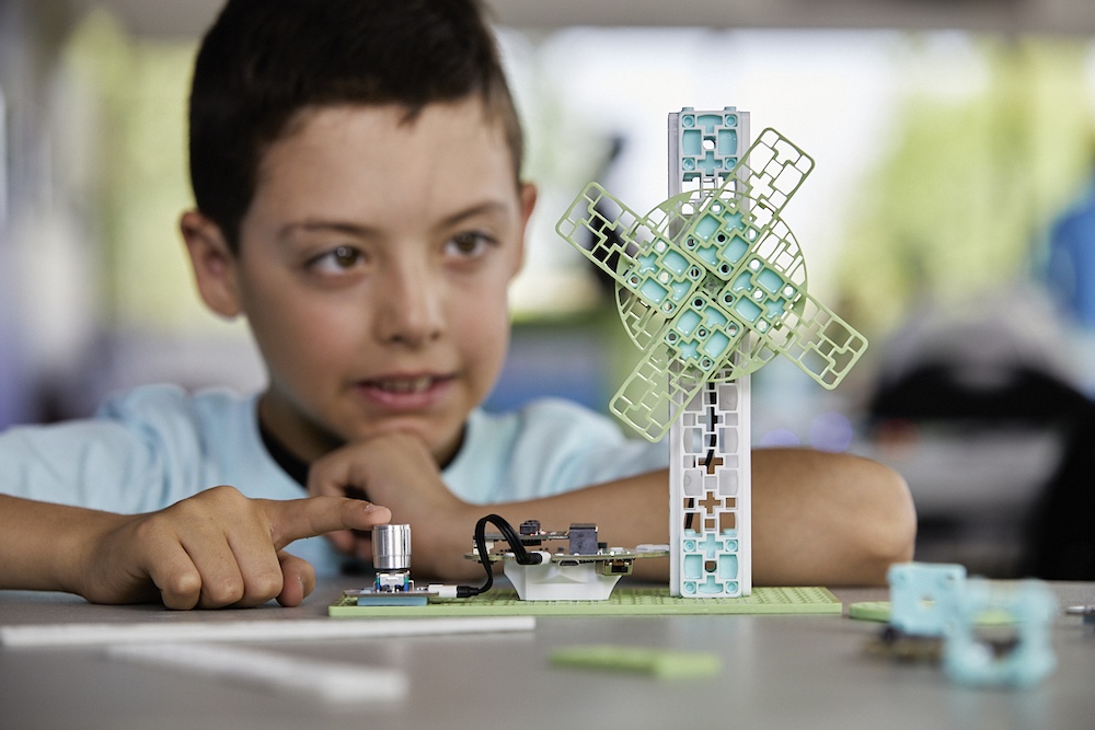 Male student looking at the Wind Turbine Climate Action Kit project on the desk
