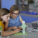 Two girls sitting at a desk working on the Wind Turbine project from the Climate Action Kit