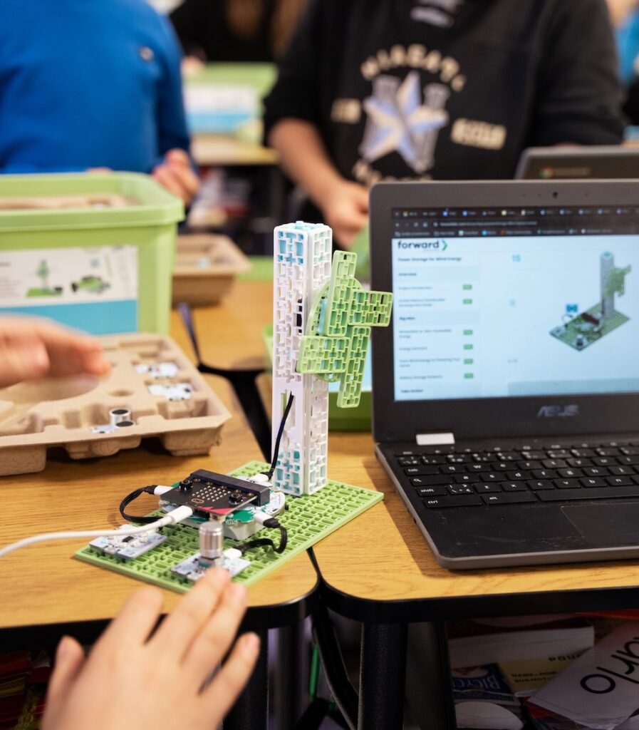 Wind Turbine project from the Climate Action Kit sitting on a desk beside a laptop