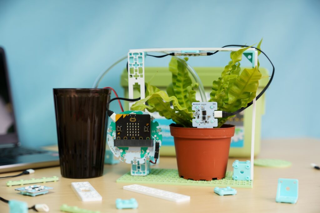 Smart Farming project from the Climate Action Kit showing a micro:bit, plant, and cup of water