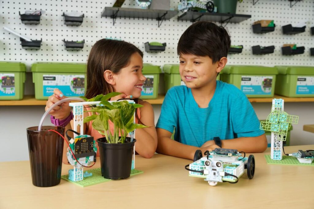 Two students looking at various micro:bit projects from the Climate Action Kit