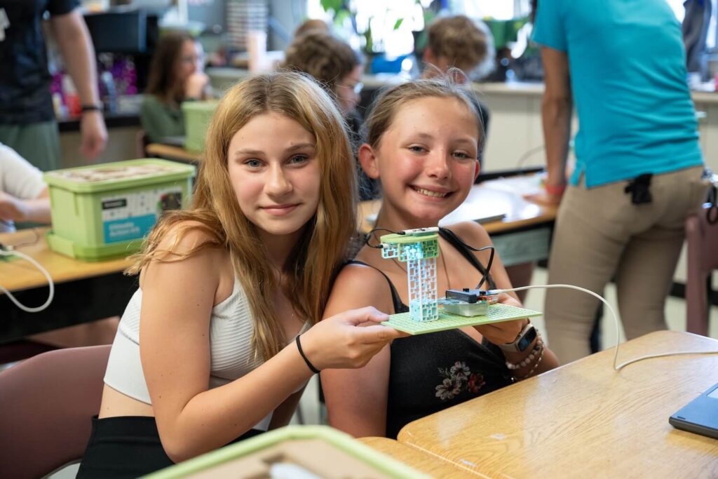Two female students holding the Turtle-Safe Beach Lighting project from the Climate Action Kit
