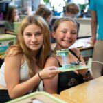 Two female students holding the Turtle-Safe Beach Lighting project from the Climate Action Kit