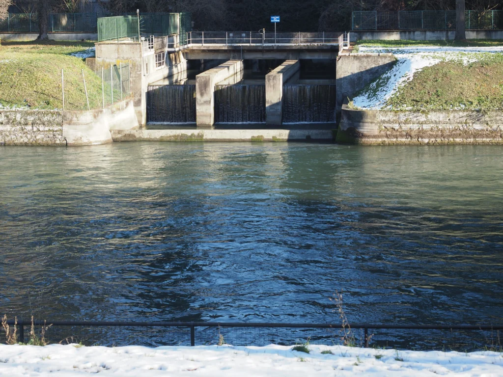 A thermoelectric power station with a dam structure and flowing water in a controlled channel.