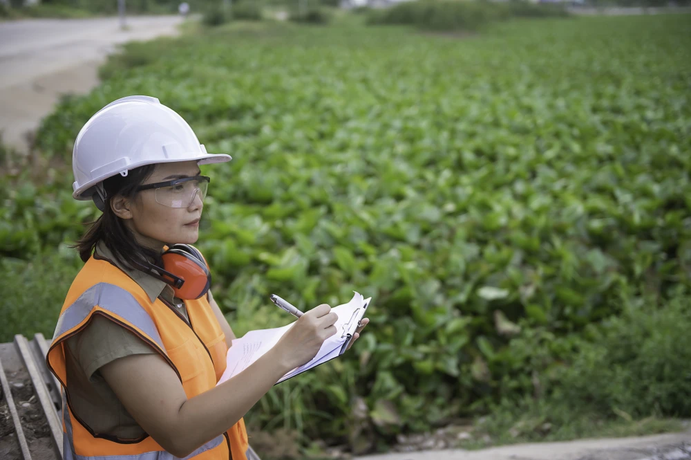 Engineer taking notes in front of a field.