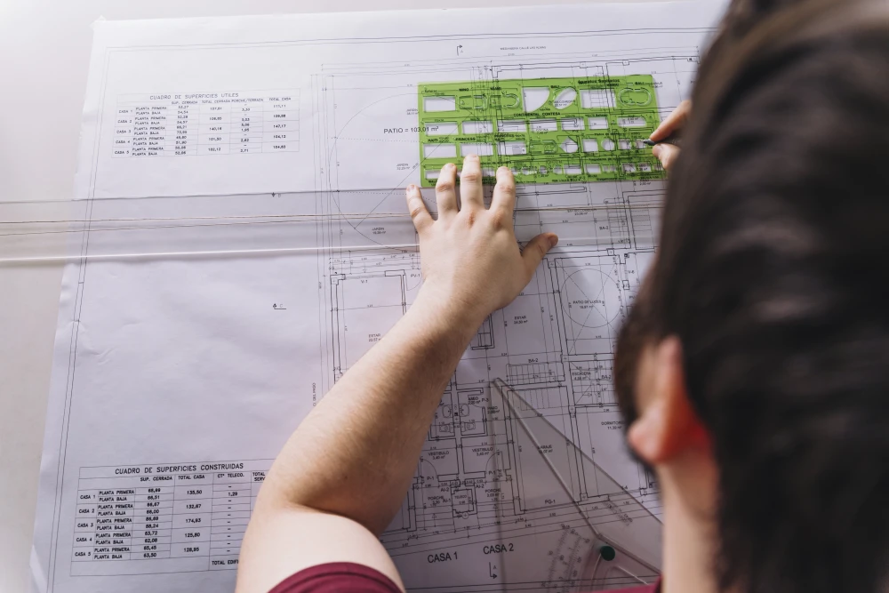 Looking over the shoulder of an architect using a template to add detail to a schematic.