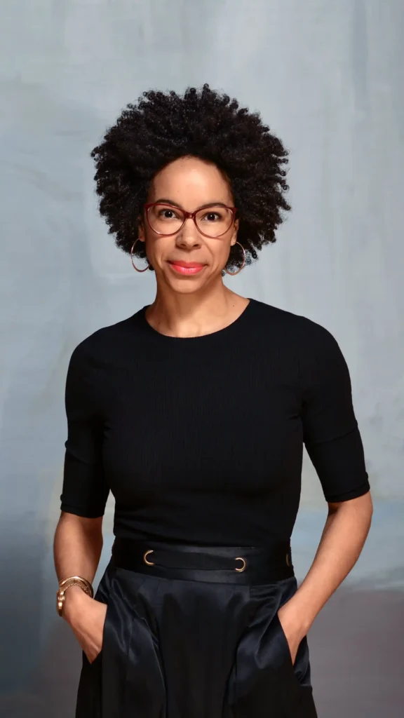 Ayana Elizabeth Johnson stands for a portrait, smiling into the camera.
