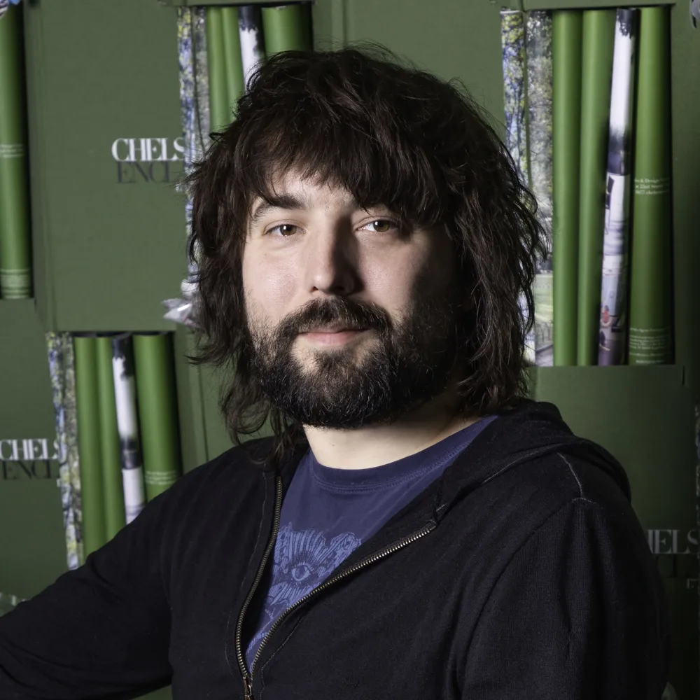 Headshot of Tom Szaky in front of a wall of recycled books.