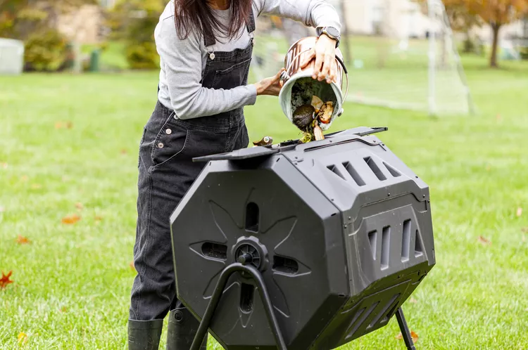 Person pouring food scraps into a large octagonal tumbling composting.