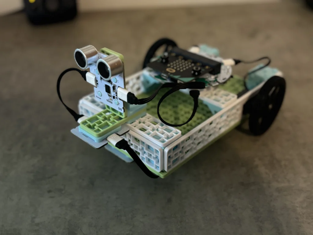 Real build of smart warehouse vehicle on teacher desk.