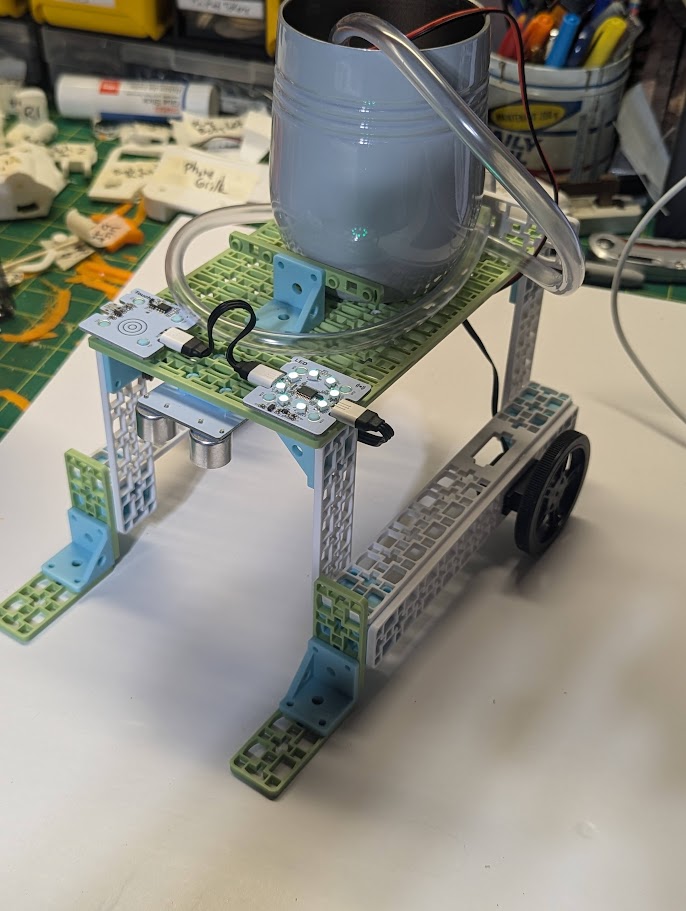 Real build of mobile irrigation vehicle on teacher desk.