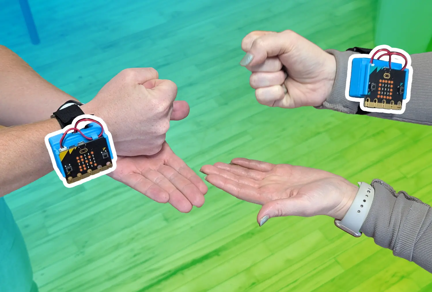 Two people's hands playing Rock Paper Scissors with CHARGE power packs and micro:bits attached to their wrists. A blue to green gradient is overlaid behind the micro:bit which has a white boarder around it.