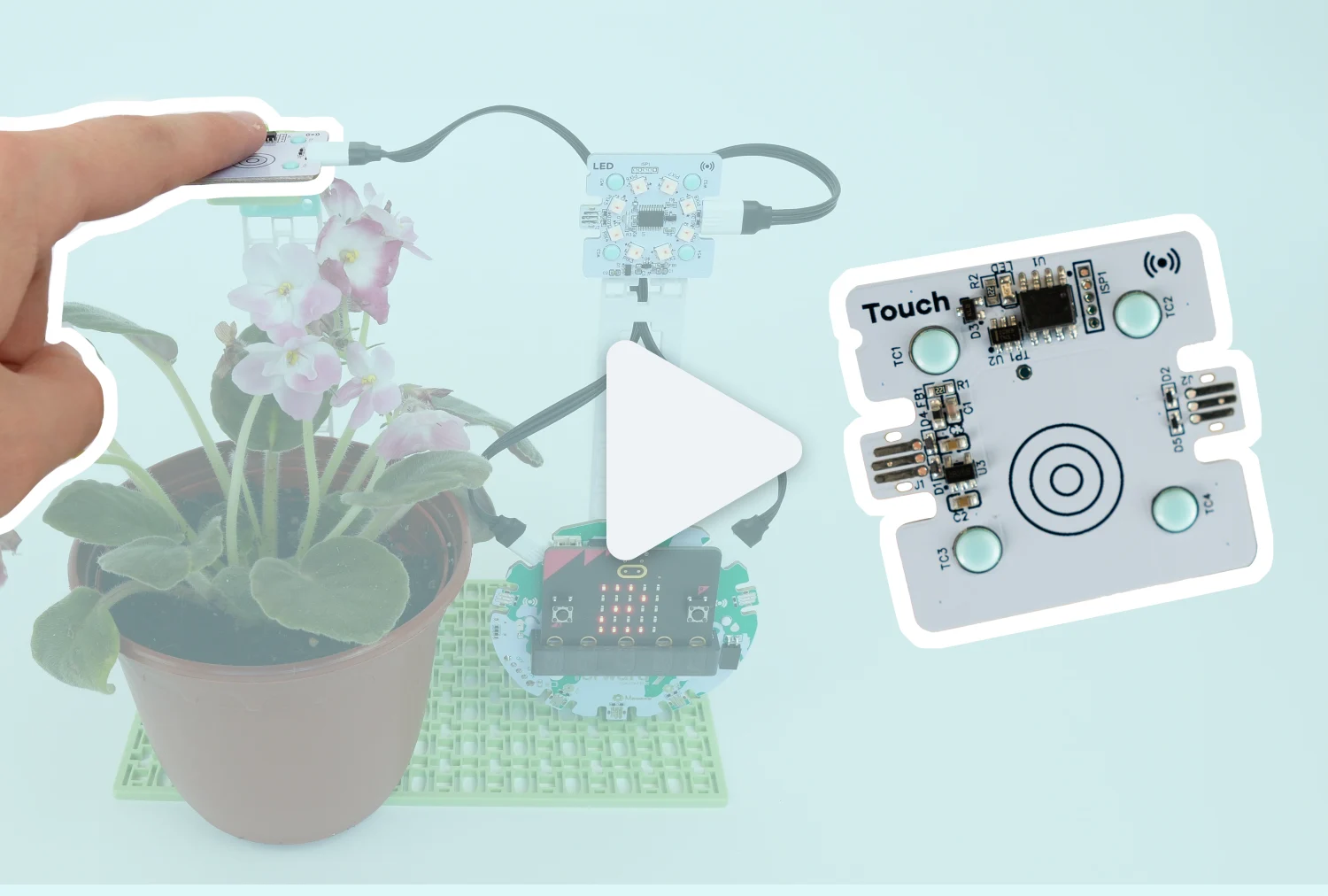 A highlighted touch sensor on a project with a flower beside an enlarged touch sensor with a large video play button in the centre.