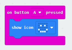 This example uses the MakeCode editor where blocks snap together to create the algorithm. In this case, there is a pink Input or Event block that says 'on button A pressed' wrapped around a blue output block that says 'show icon smiley face'.