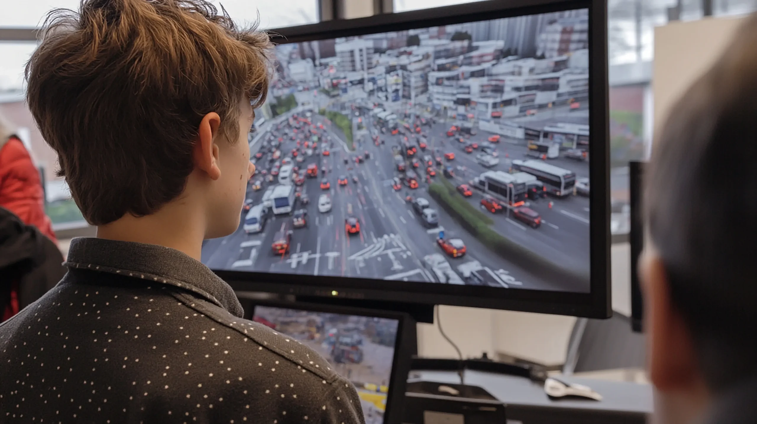 A person sitting at a computer reviewing a road filled with vehicles