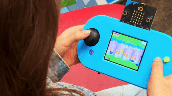 A child uses the CodeCTRL to play a video game that has been loaded on the micro:bit. They are using the CodeCTRL's joystick to control the main character.