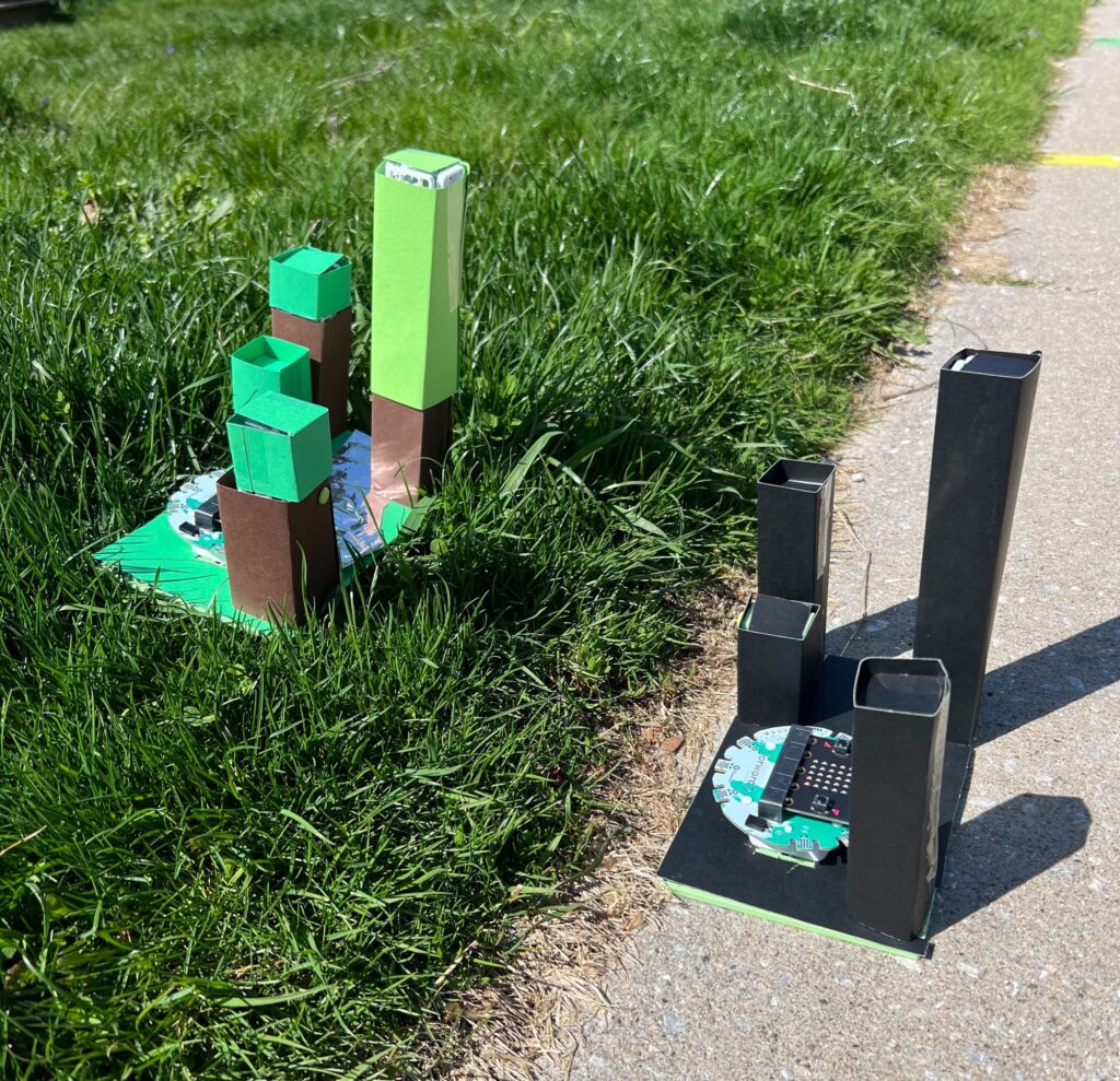 Custom model cities/parks used in Urban Heat Island experiment conducted outdoors. The green park is placed on grass. The dark city model is placed on cement.