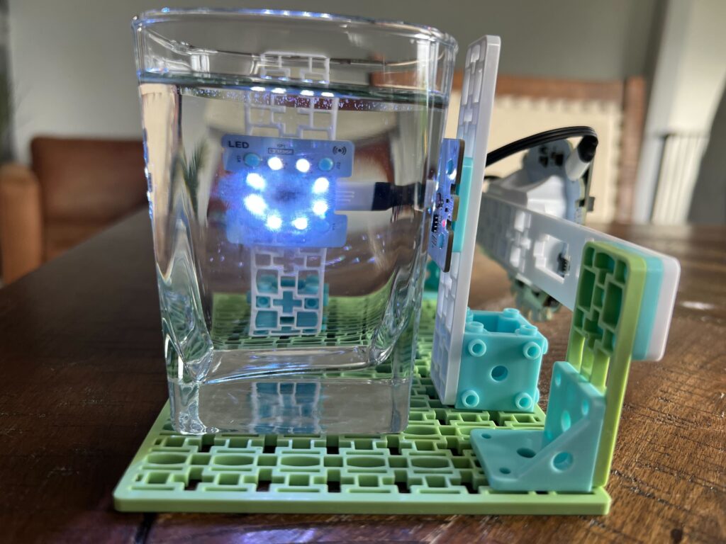 An NTU sensor setup with a clear glass of water positioned between the LED ring and the solar sensor. The LED ring is facing the camera so you can see the light shining through the sample.