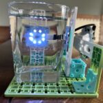 An NTU sensor setup with a clear glass of water positioned between the LED ring and the solar sensor. The LED ring is facing the camera so you can see the light shining through the sample.