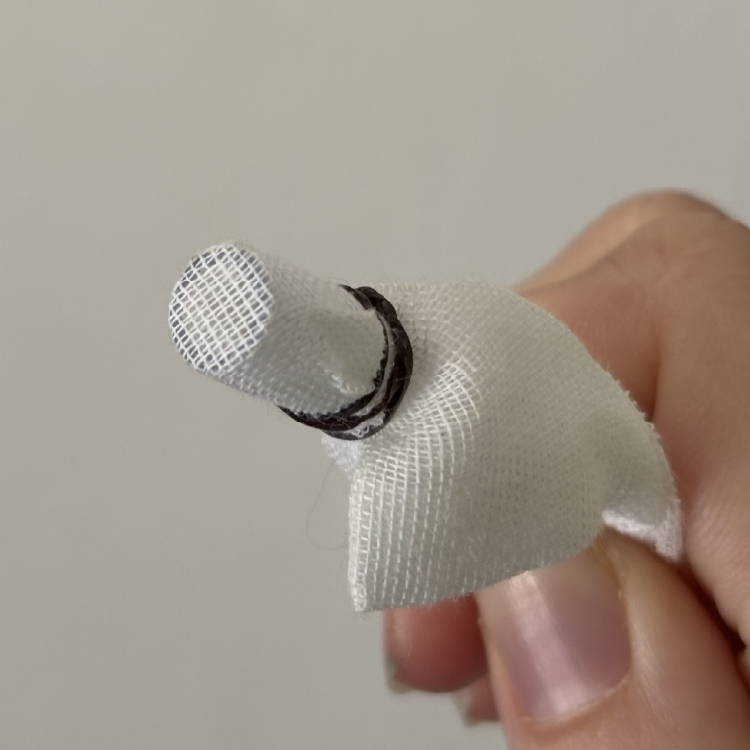 A piece of cheesecloth is attached to a water tube using an elastic band to prevent debris from damaging the peristaltic pump.