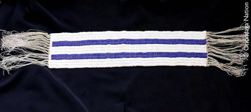 The Two Row Wampum Belt (Kaswentha) features two parallel rows of purple beads separated by three rows of white beads, symbolizing a foundational treaty agreement.