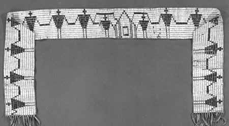 A black and white photograph of the Washington Covenant Wampum Belt, which is shaped like a wide arch and depicts figures holding hands on either side of a central longhouse.