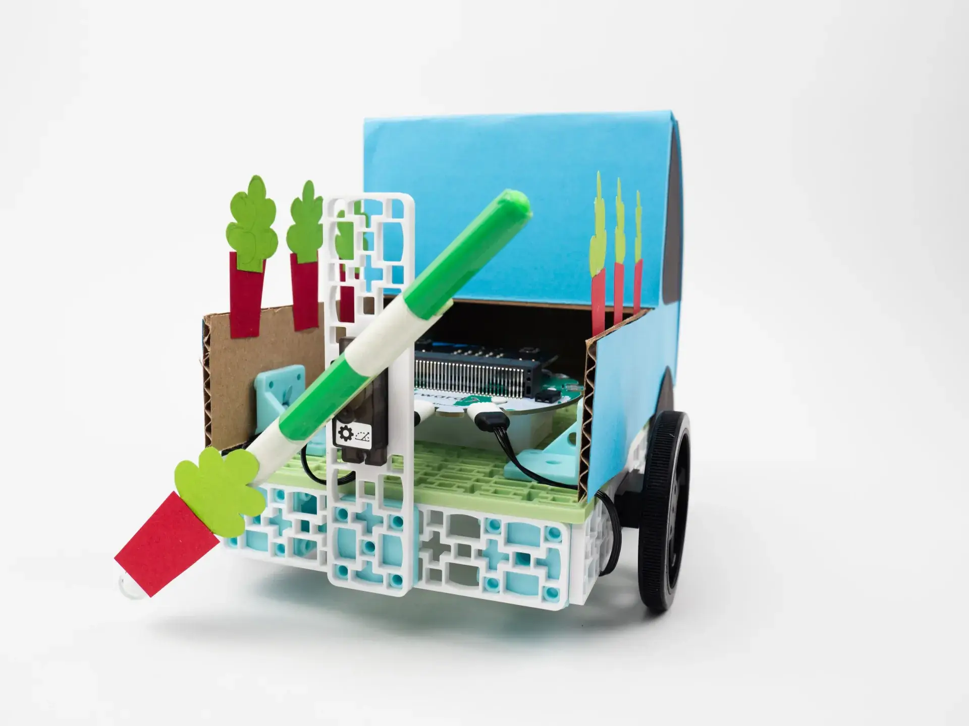 Tree seeder build with construction paper added to the frame to add new design elements. For example, there are blue sides to the vehicle and trees coming out of the "trunk".